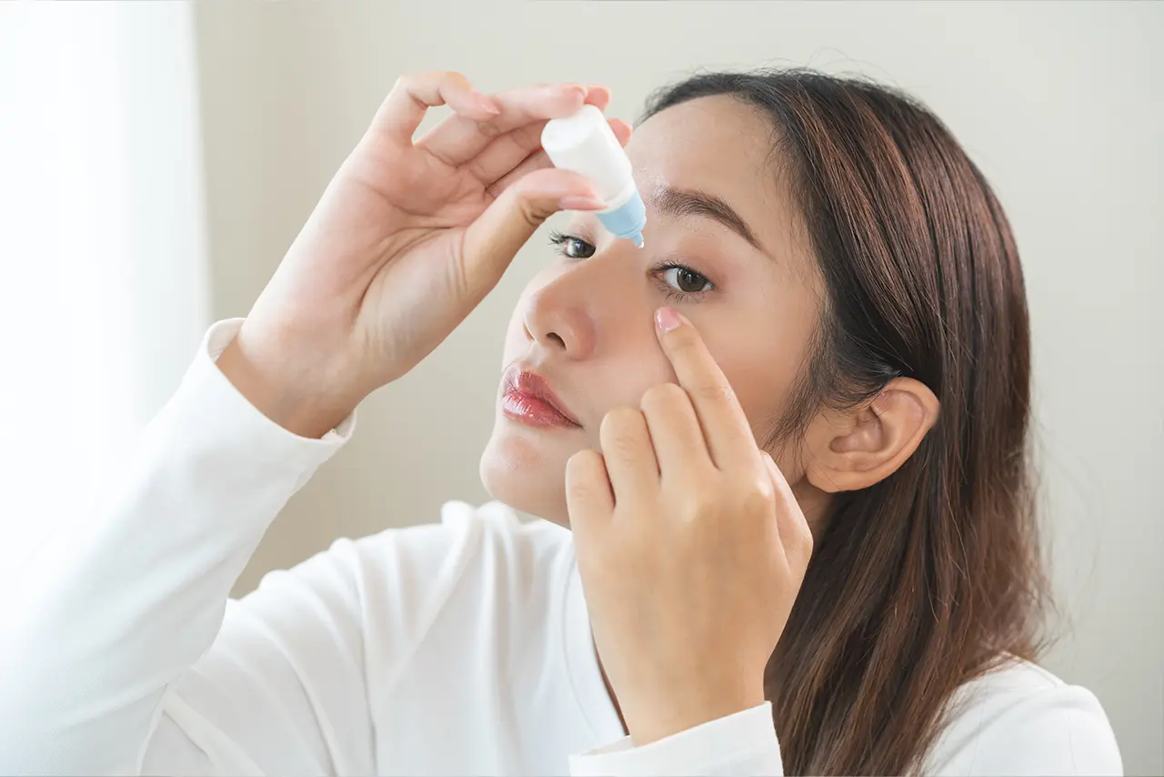 Close-up of a patient using eye drops to support healing after a cataract procedure.
