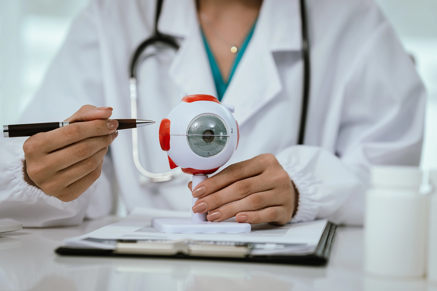 A specialist referring to a model of the human eye while explaining cataract surgery options