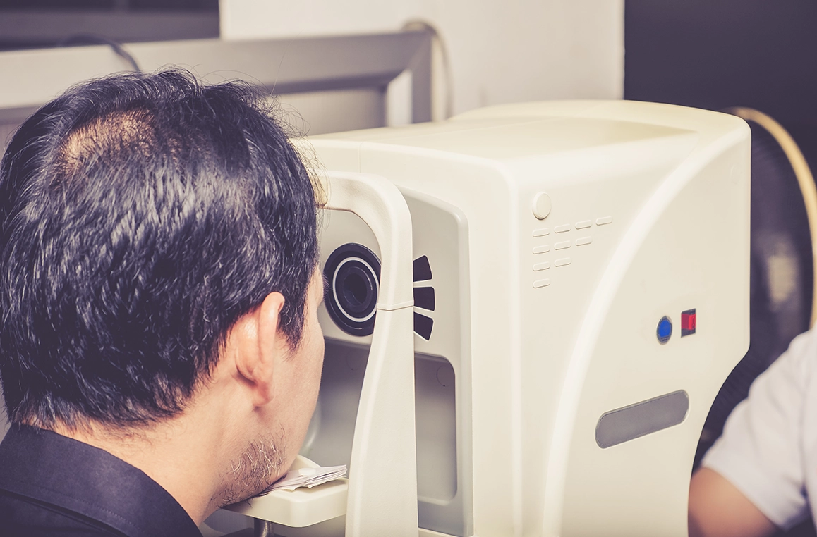 Man undergoing retinal examination for eye floaters