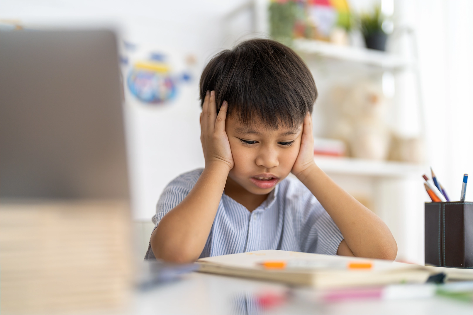 Young boy with headache struggling to read book