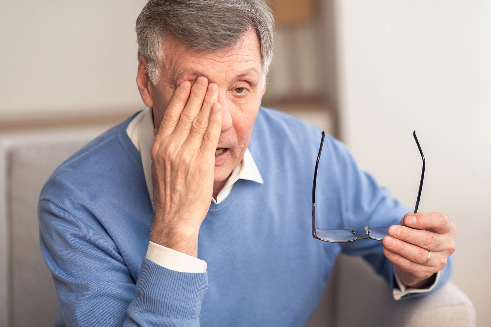 An elderly man experiencing discomfort due to glaucoma