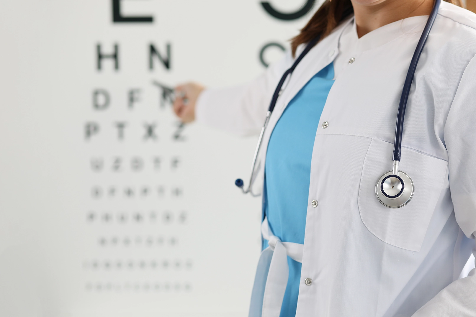 An ophthalmologist pointing to an eye chart