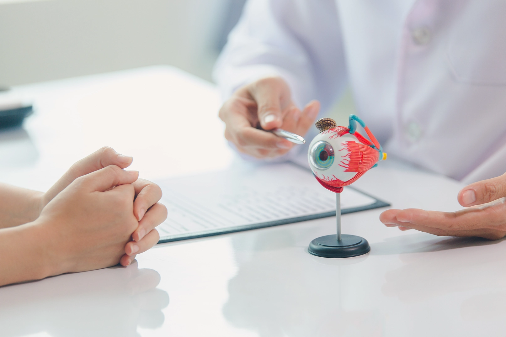 An ophthalmologist pointing to an anatomical diagram during a consultation