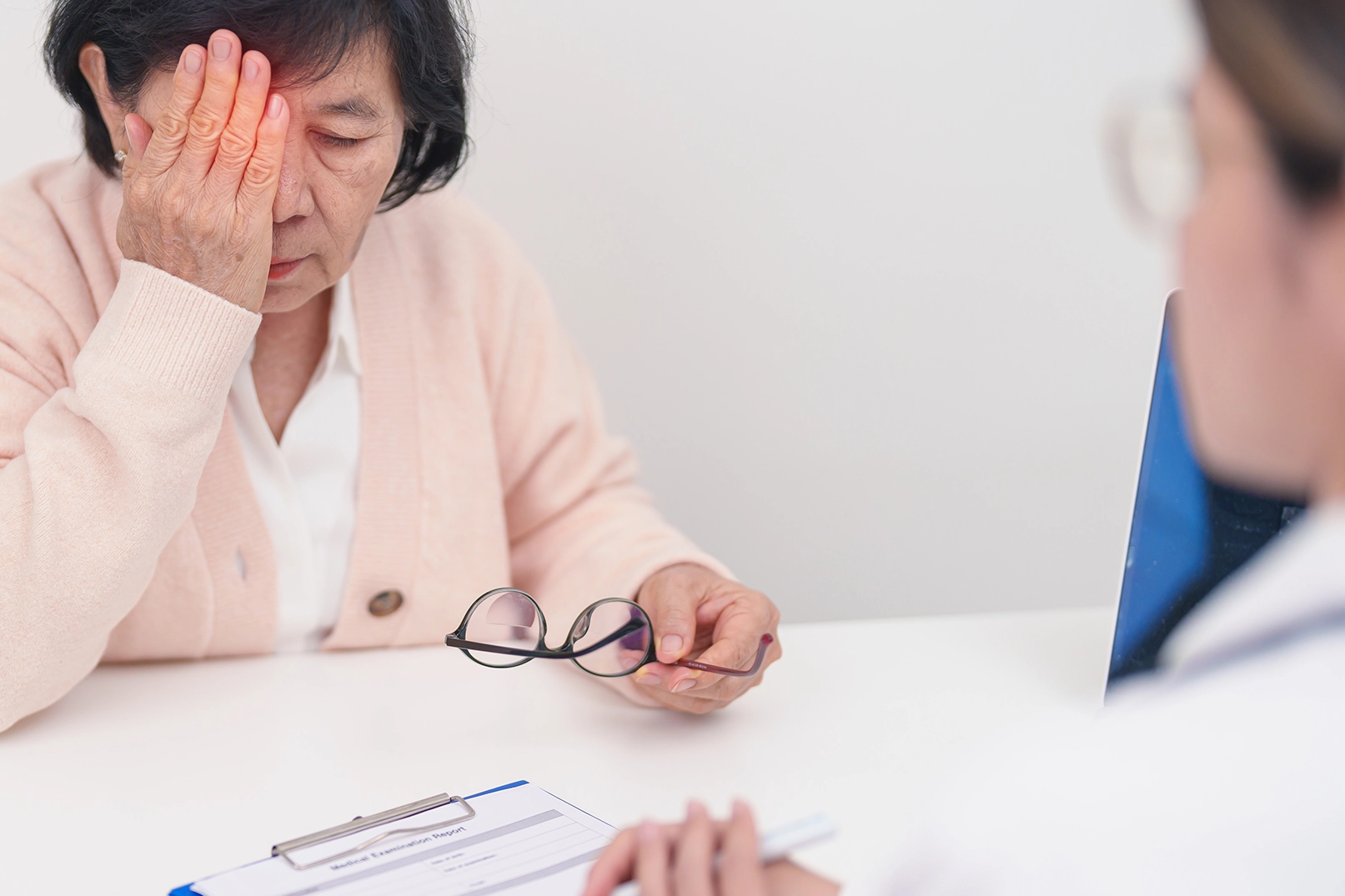 Elderly woman patient having eye ache and consulting doctor