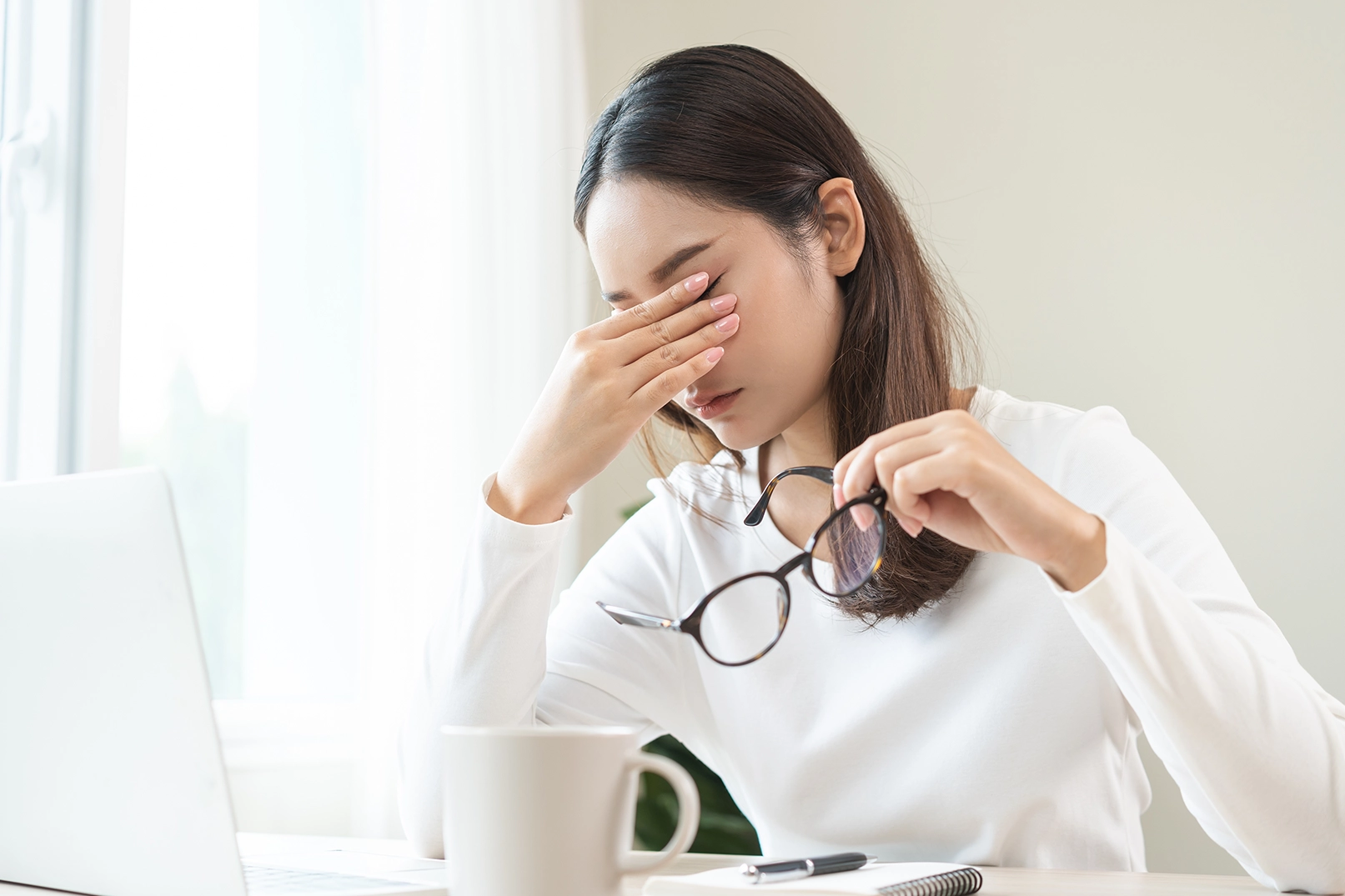 A woman experiencing painful eye symptoms